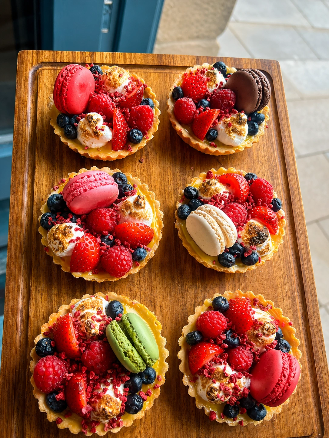 Berry tartlets topped with fruit and macarons